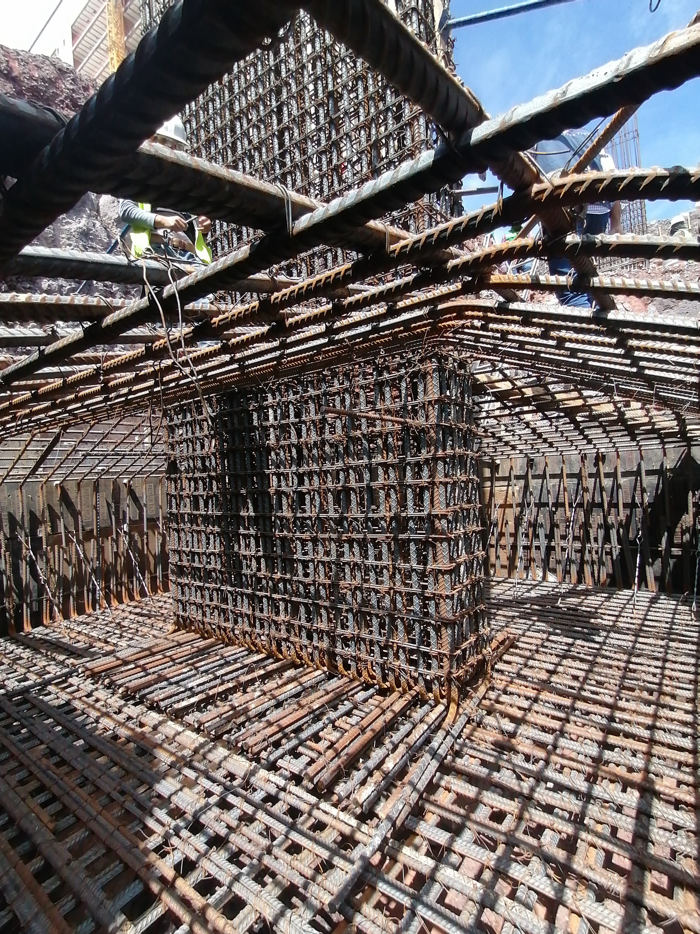 Detalle técnico de un proyecto de construcción: estructura de acero y concreto bajo iluminación focalizada